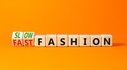 Fast or slow fashion symbol. Concept words Fast fashion and Slow fashion on wooden cubes. Beautiful orange table orange background. Business fast or slow fashion concept. Copy space. - obrazy, fototapety, plakaty