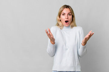caucasian blonde woman feeling extremely shocked and surprised. copy space concept