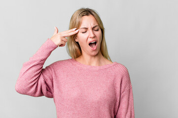 caucasian blonde woman looking unhappy and stressed, suicide gesture making gun sign