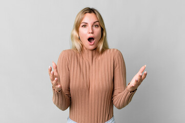 caucasian blonde woman feeling extremely shocked and surprised