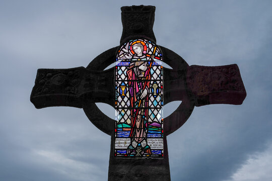 Double exposure image of stained glass and St. Martin's cross inside the Benedictine Abbey on Iona, Scotland; Iona, Isle of Iona, Scotland
