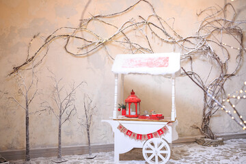Street Food Promotional counter cart outdoors on Christmas eve. Decorative vintage white wooden retro kiosk, candy bar desserts, delicious sweets in winter. Festive market concept. Xmas celebration.