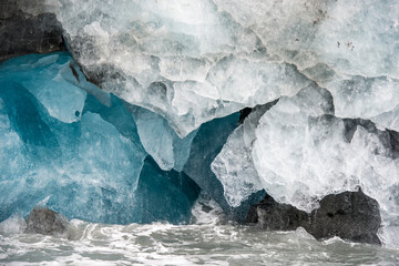 Abstract shapes of glacial ice beside the waves of the Southern Ocean; South Georgia Island, Antarctica