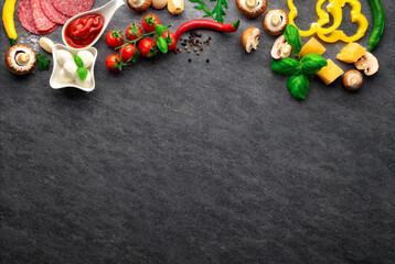 Fototapeta na wymiar Set ingredients for cooking italian pizza on a dark stone background with copy space, top view