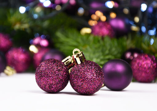 Beautiful purple Christmas glitter balls and light Christmas garland stock images. Purple baubles decoration with lights still life stock photo. Purple shiny christmas ornament image