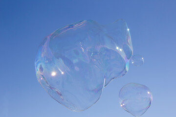 A giant soap bubble in the sky, and a smaller one by its side