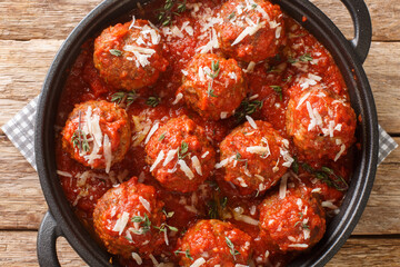 Italian Traditional Dish Polpette al sugo meatballs in tomato sauce on pan on wooden table. Horizontal top view from above