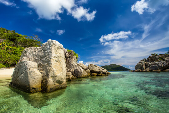 Granite rock formations define a tropical beach.