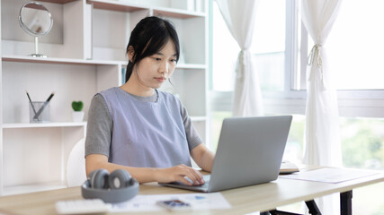 Young studying online uses his laptop in a live performance to communicate with his friends and teachers, Using laptops and data graphs in class, Online communication, Social distancing.