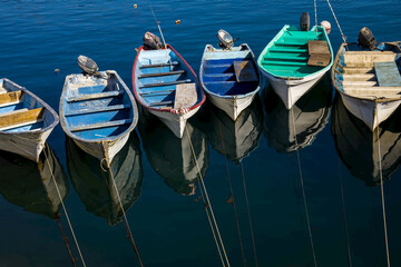 Fishing boats rest at the dock on a sunny day.