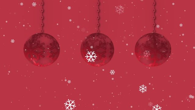 Red Christmas bauble decorations in a row on red background with snowflakes 