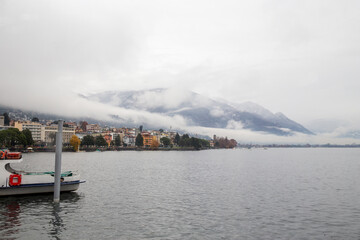 Naklejka na ściany i meble Amazing foggy landscape of Locarno with clouds and mountains