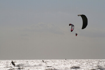 A father and son kite board together on the Pamlico Sound.; Nags Head, North Carolina.