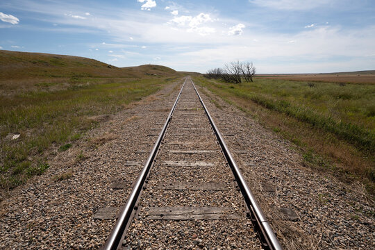 Railroad tracks on a vast landscape of the Canadian prairies leading into the distance; Sanctuary, Saskatchewan, Canada