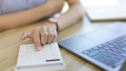 Businesswoman presses a calculator to calculate earnings and analyze company earnings in his private office, Information in finance and accounting, Company performance and revenue.