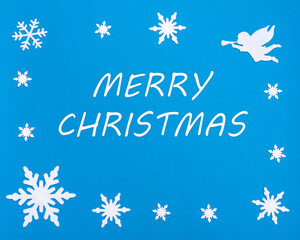 Christmas greeting card. HAPPY CHRISTMAS text on a blue background with Christmas snowflakes, a white angel