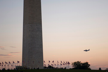 An airplane flies near The Washington Monument in Washington, DC, USA; Washington, District of Columbia, United States of America