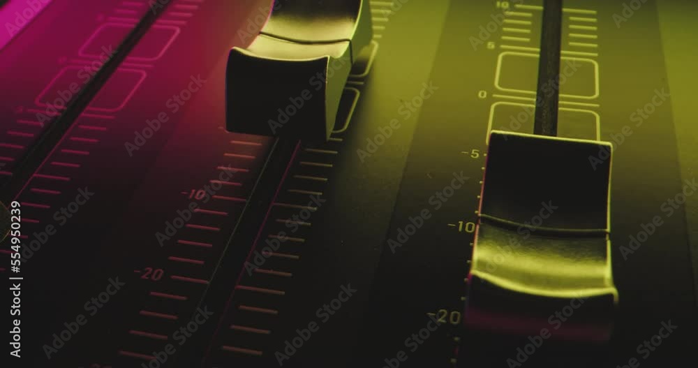 Poster volume control slider on audio mixer in colorful flickering party light is pushed to the maximum
