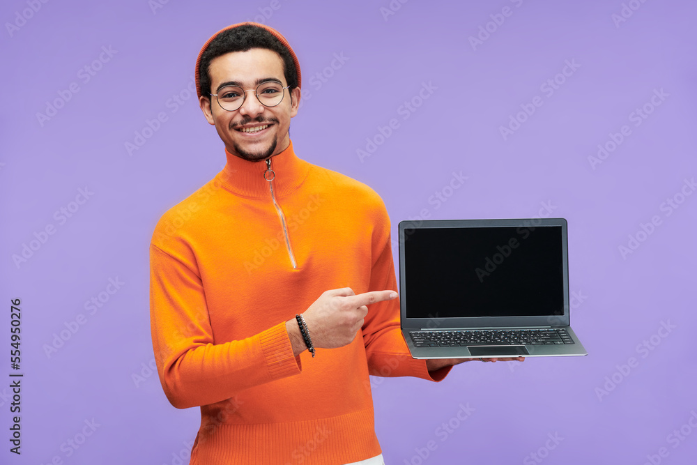 Aufkleber Young successful programmer pointing at blank screen of laptop while making presentation of new software and looking at camera