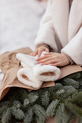 Christmas tree branches, female hands and mittens