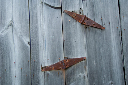 Close-up of an old rusty hinges on a wooden door; Cortland, Nebraska, United States of America