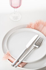 Empty white plate with cutlery on white background. Beautiful  table setting. Selective focus.