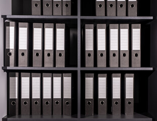 Office binders, folders, business documents on shelf in office. Rows of same files. Archive,...