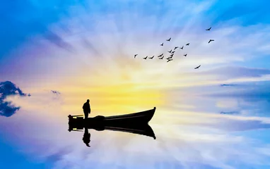 Fototapeten silueta de una barca en el mar al atardecer  © kesipun