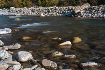 A long exposure on the river flowing through the rocks. Water flowing over rocks. Long exposure time. A long exposition of the river in the Caucasus mountains. 