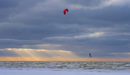 Kite surf in flight in winter. Sunset sky.