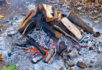Obraz premium Top of a large circular bonfire packed with firewood on the sides that smoke comes from the wooden logs in a popular village festival for typical rural celebration
