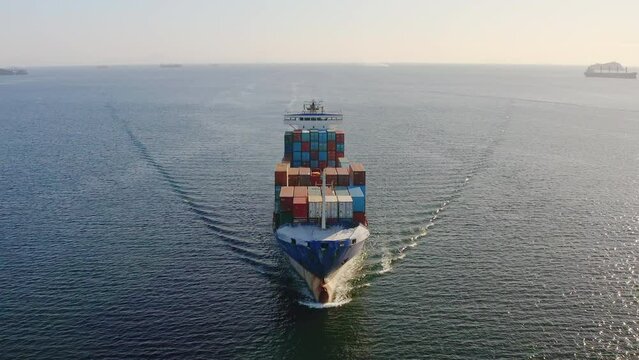 A close-up view of the bow of a container ship breaking waves