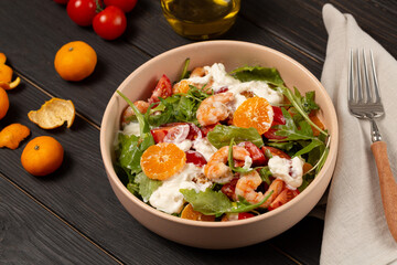 Fresh light salad with arugula, shrimp, tangerines, strachatella cheese, cherry tomatoes