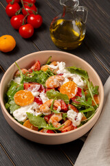 Fresh light salad with arugula, shrimp, tangerines, strachatella cheese, cherry tomatoes