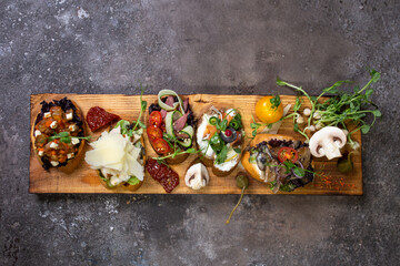 top view assorted bruschetta with different flavors on a wooden board