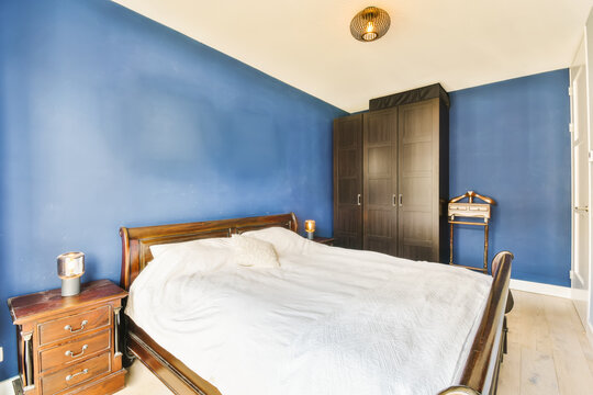 A Bedroom With Blue Walls And White Bed Spread Across The Room, While It Is Not In Use Or Used