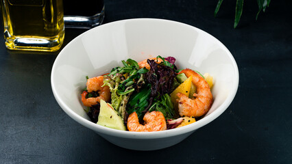 Fresh salad with fried shrimp, cucumbers, sweet peppers, arugula, lettuce, sesame seeds and olive oil.