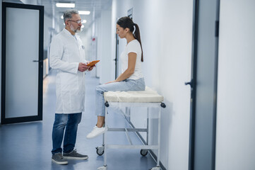 Gray-haired doctor talking to the patient before MRI