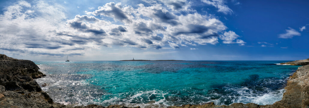 Panoramic view of lighthouse in Mediterranean sea off the coast of Menorca at Punta Prima.