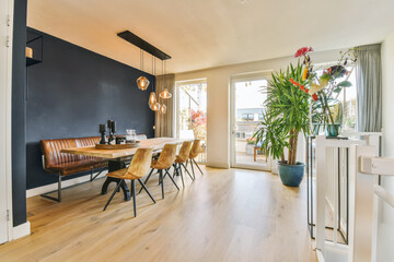 a dining room with wood flooring and black wall painted in the same color as it appears on the walls