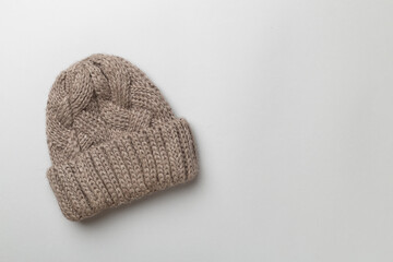 Grey winter hat on color background. Top view