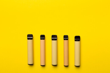 Disposable electronic cigarettes on color background, top view