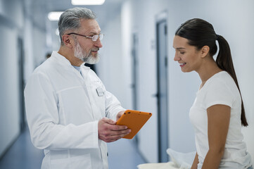 Gray-haired doctor talking to the patient before MRI