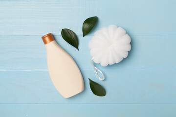 Shower gel with washcloth on wooden background, top view