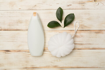 Shower gel with washcloth on wooden background, top view