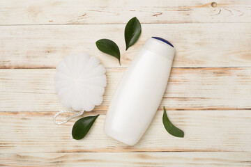 Shower gel with washcloth on wooden background, top view