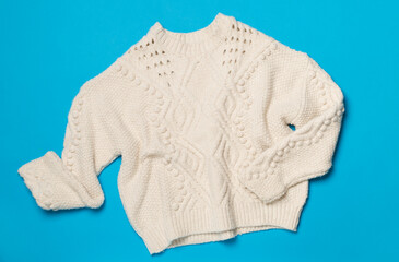 Sweater on color background, top view