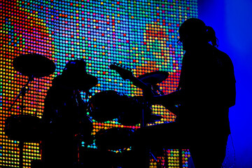 Disco party background. Rock singer on scene in club. Bright stage lighting. Band Blue Silhouette.  