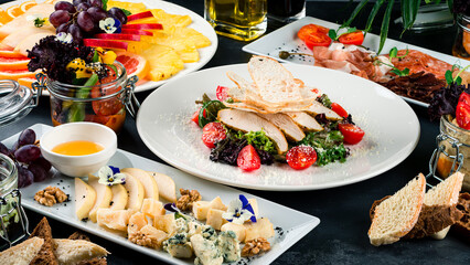 food background Restaurant banquet menu Caesar salad, a plate with cheese, a meat plate and fruit plate. Italian traditional cuisine.