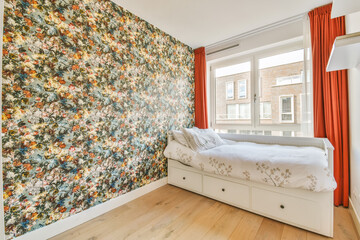 a bedroom with floral wallpaper on the walls and wooden flooring in front of the bed, there is an...